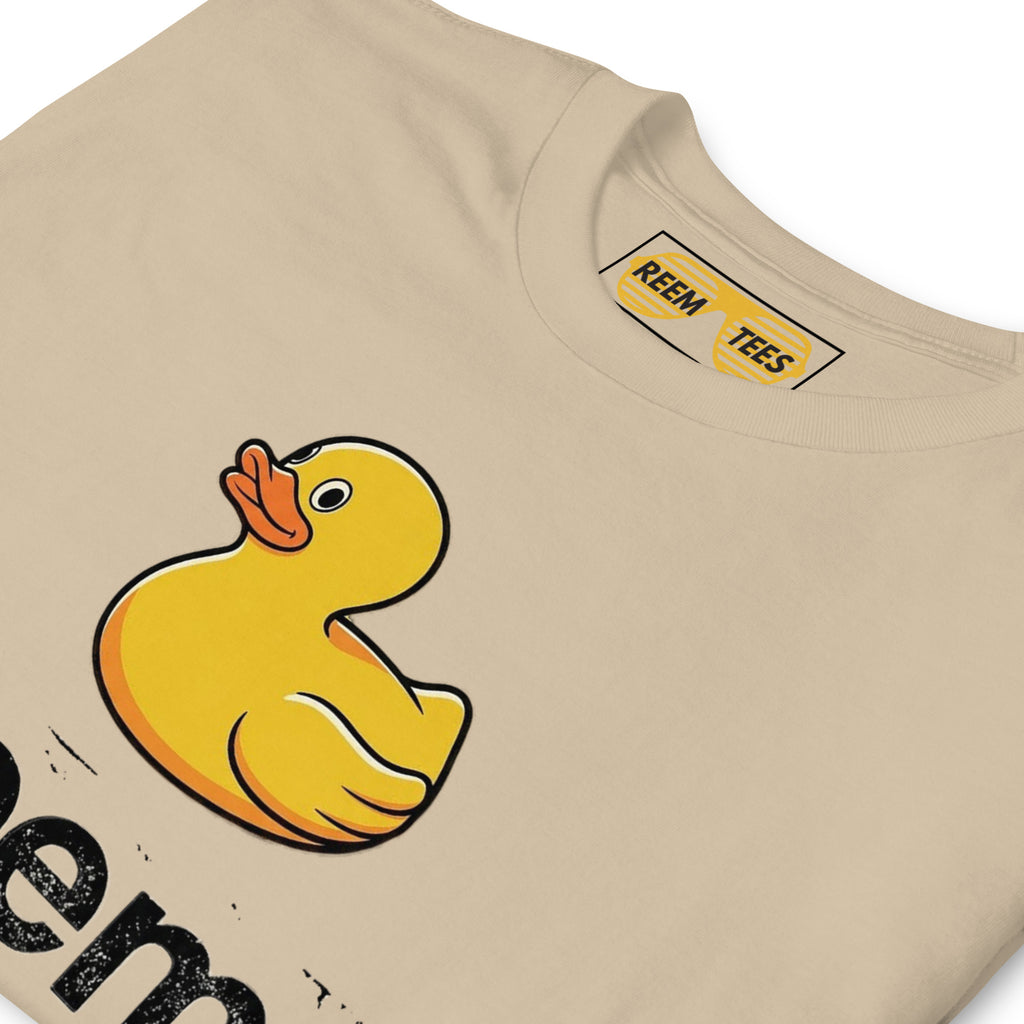 Unisex CLASSIC tee by Reem Tees featuring a dark Ducks Are Reem logo on a soft sand-colored fabric.